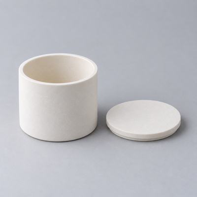 Representative product image of Alumina Crucible with Lid: round flat-bottom alumina ceramic crucible with matching lid laid beside it.